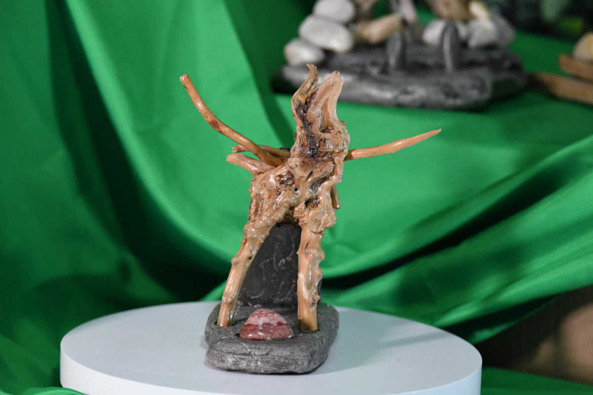 A striking handmade stained glass base with a gnarly twisted wooden branch rising from a rich dark ocean stone foundation. Accented with a warm reddish sea stone — entirely one of a kind.