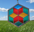 Hexagonal stained glass panel with colorful geometric design on a plain background