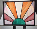 Stained glass panel with colorful design on a stand