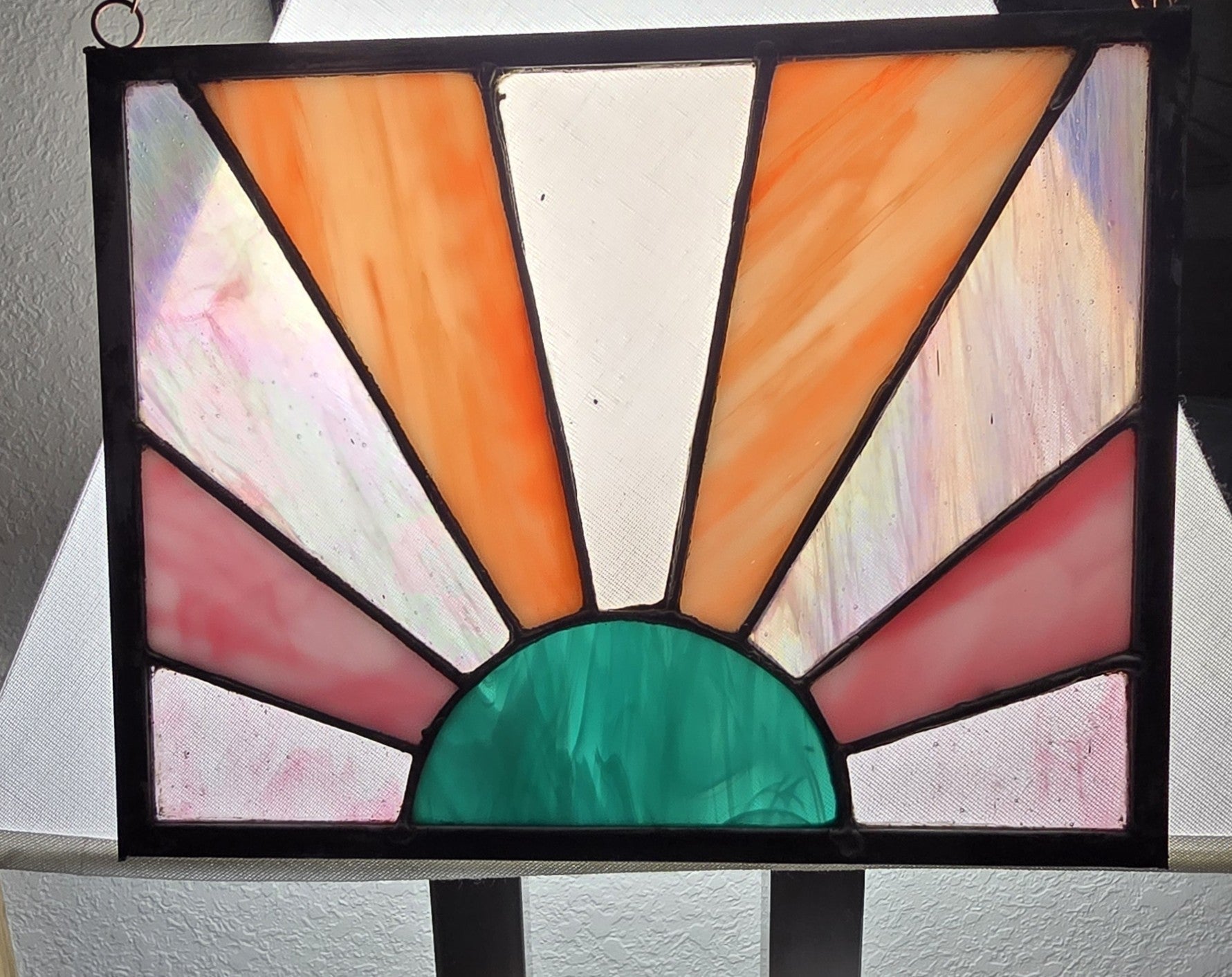 Stained glass panel with colorful design on a stand