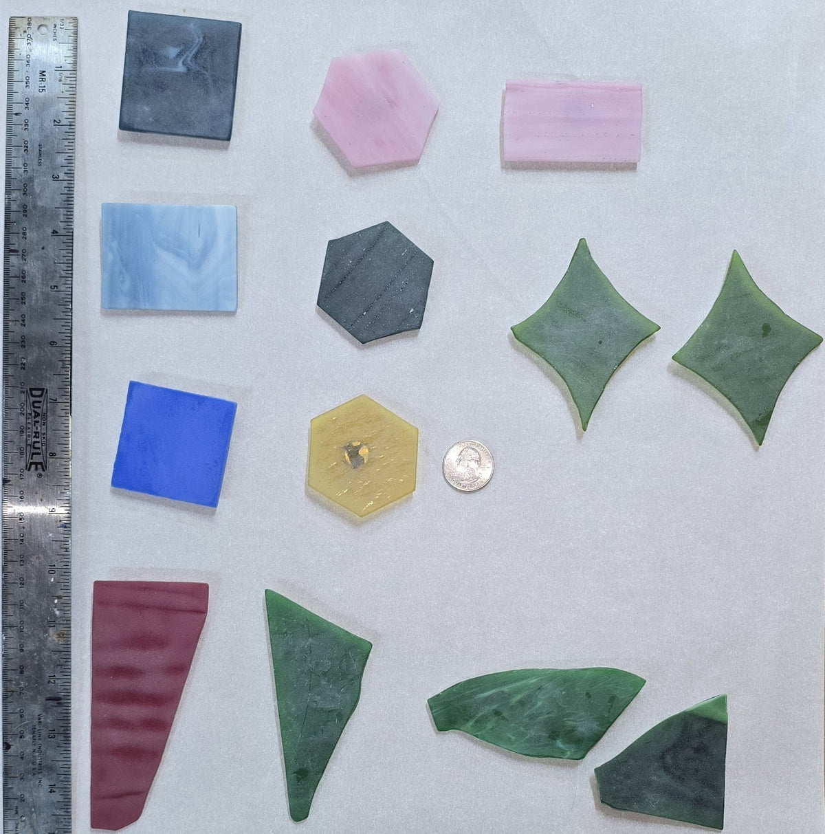 An assortment of stained-glass magnets that have been tumbled in beach sand.