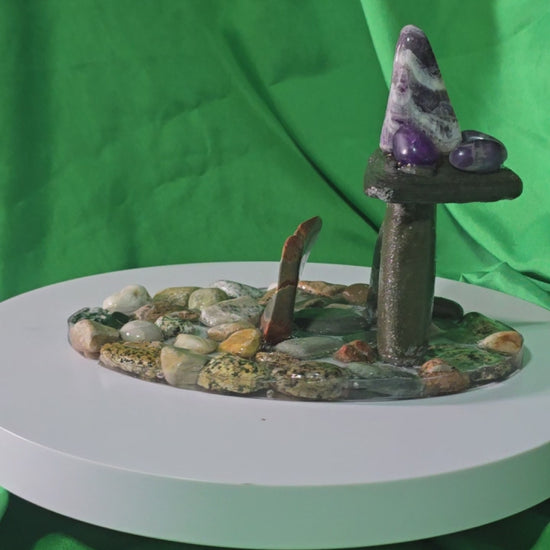 Handcrafted resin base with polished beach stones, upright stone pillars, lentil stone, amethyst cluster and amethyst chevron, epoxy‑set components with polyurethane finish
